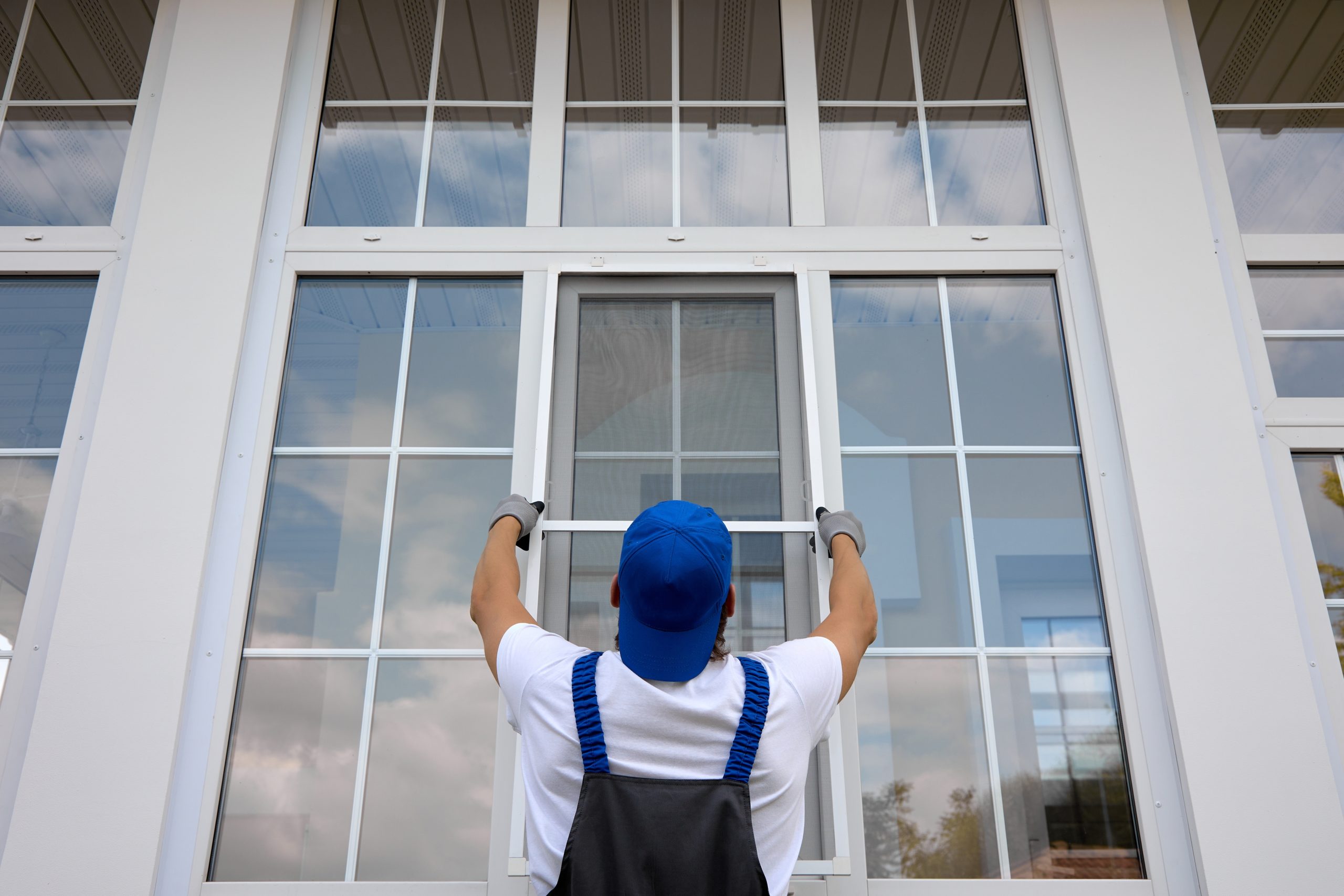 worker installing window screen
